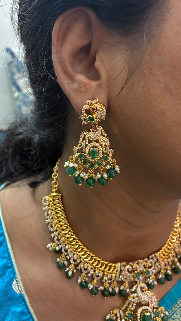 Jalebi pattern short necklace set features a Peacock pendant and green emerald beads