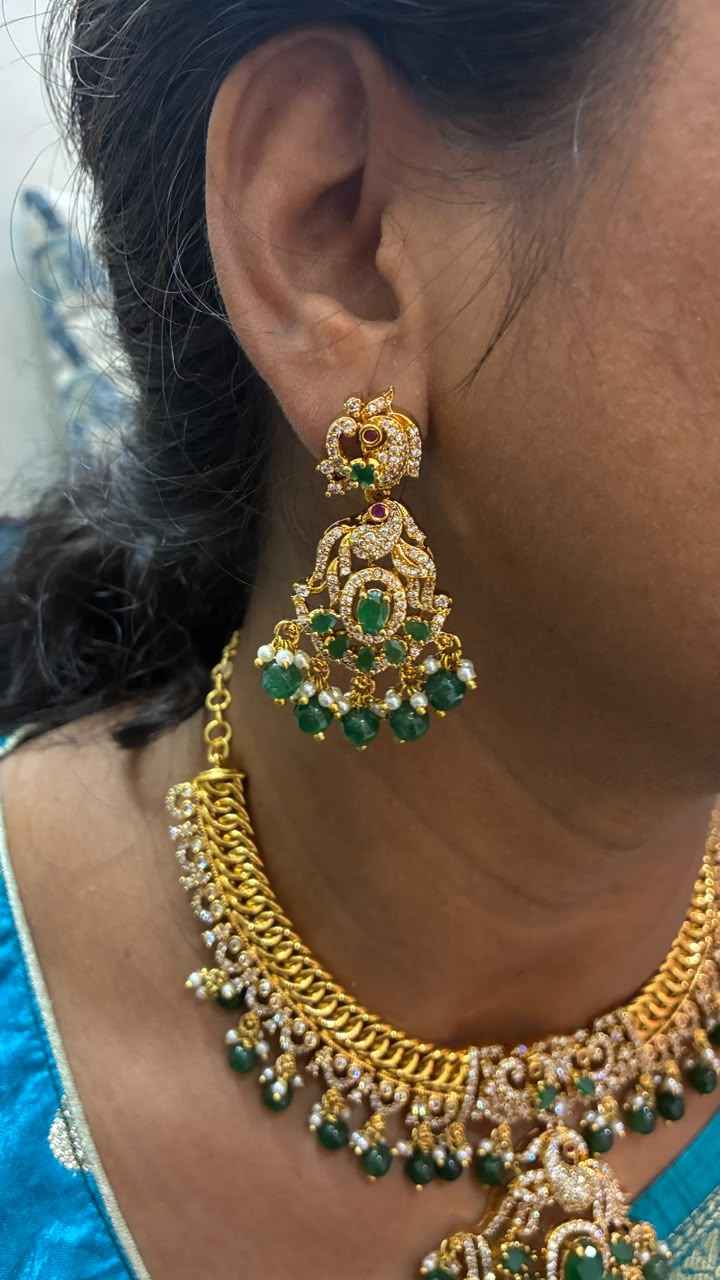 Jalebi pattern short necklace set features a Peacock pendant and green emerald beads