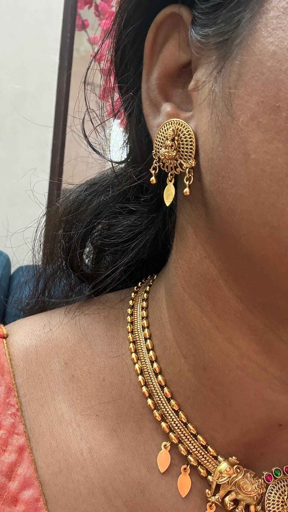 Antique gold-finish temple necklace highlighted by a central Goddess Lakshmi motif