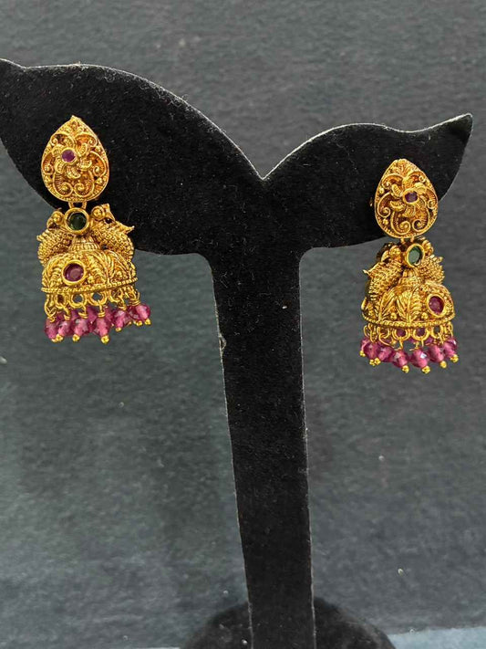 Jhumka earrings feature peacock motifs and dangling bead drops