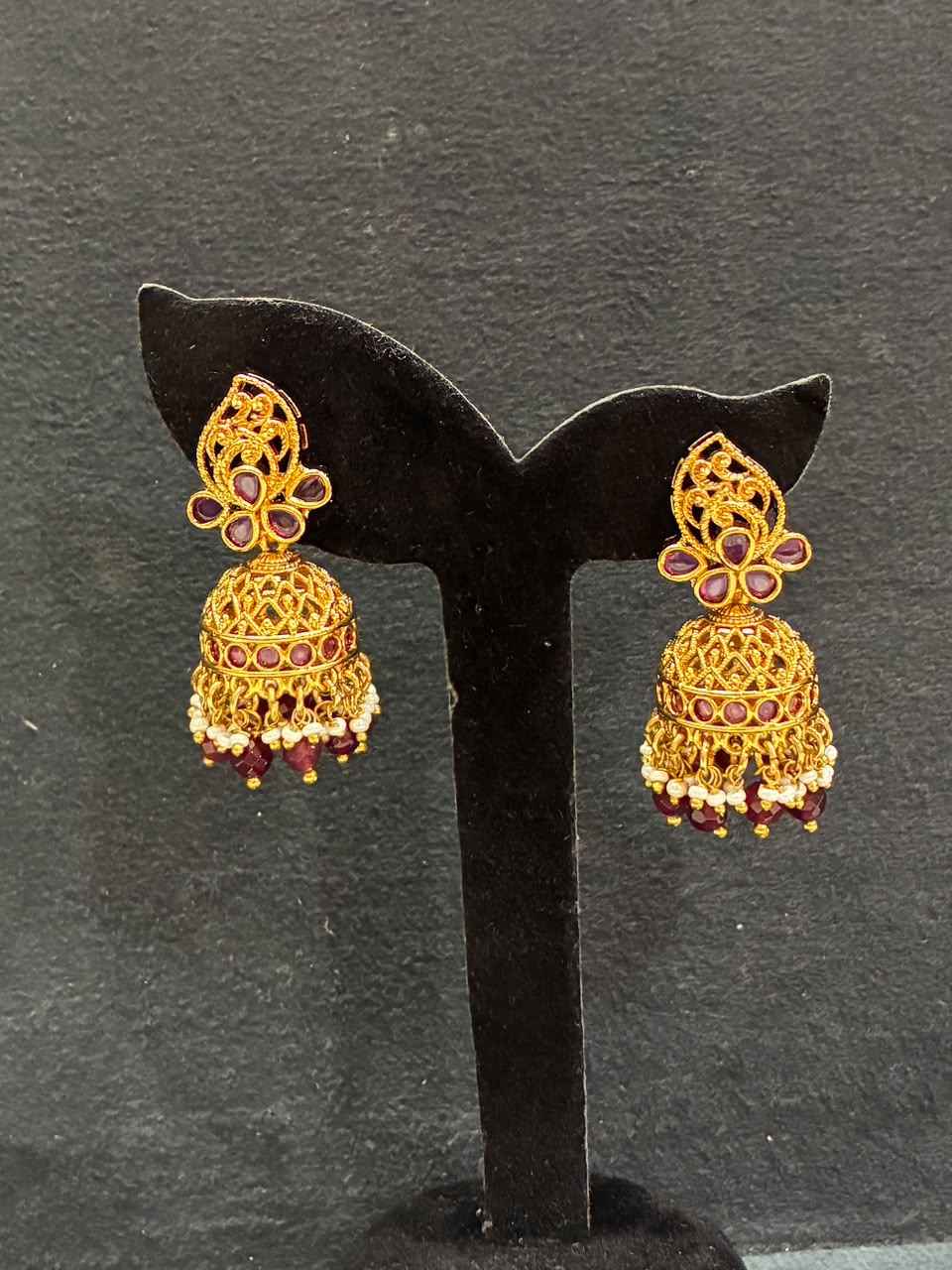 Gold-plated jhumka earrings feature a statement design