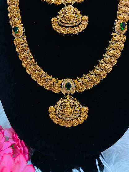 Bridal temple jewelry set features Lakshmi coin motifs and emerald stone