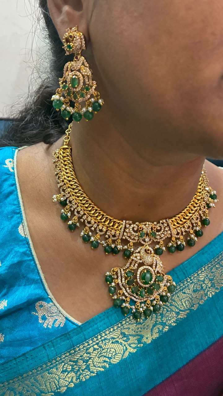 Jalebi pattern short necklace set features a Peacock pendant and green emerald beads