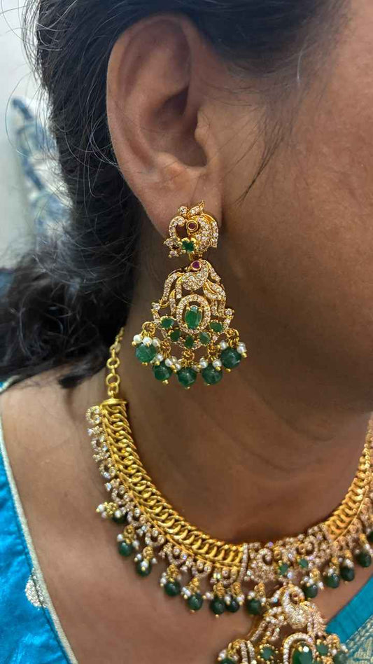 Jalebi pattern short necklace set features a Peacock pendant and green emerald beads
