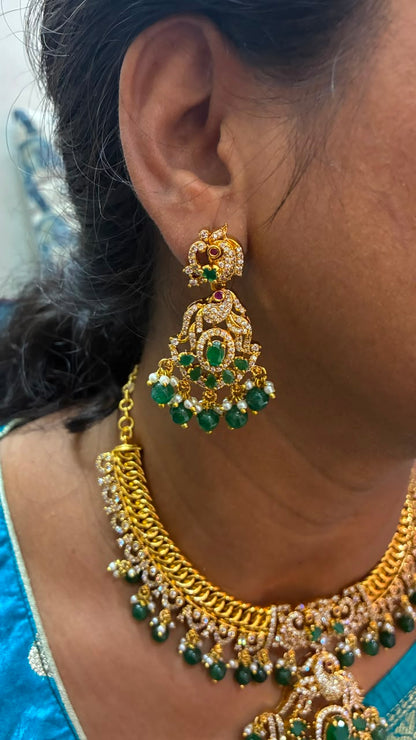 Jalebi pattern short necklace set features a Peacock pendant and green emerald beads